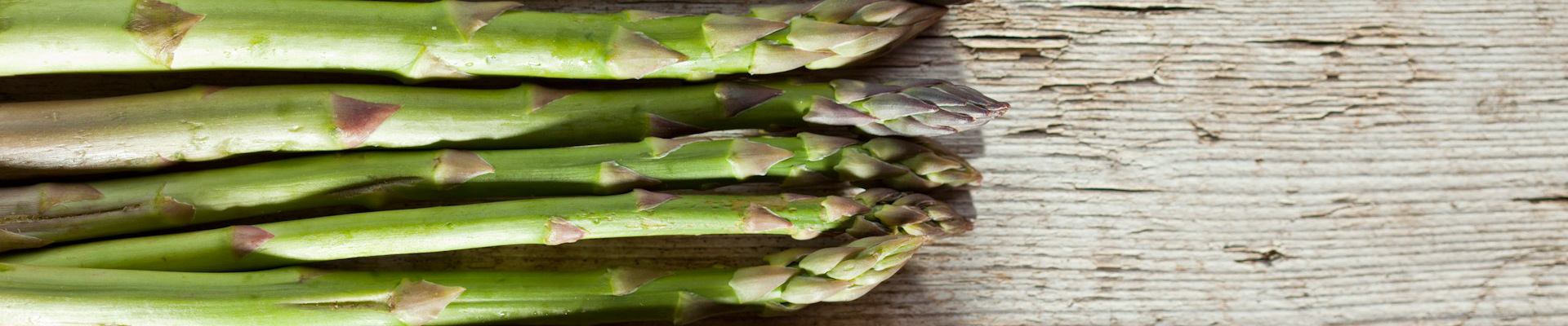 Grüner Spargel auf Holz